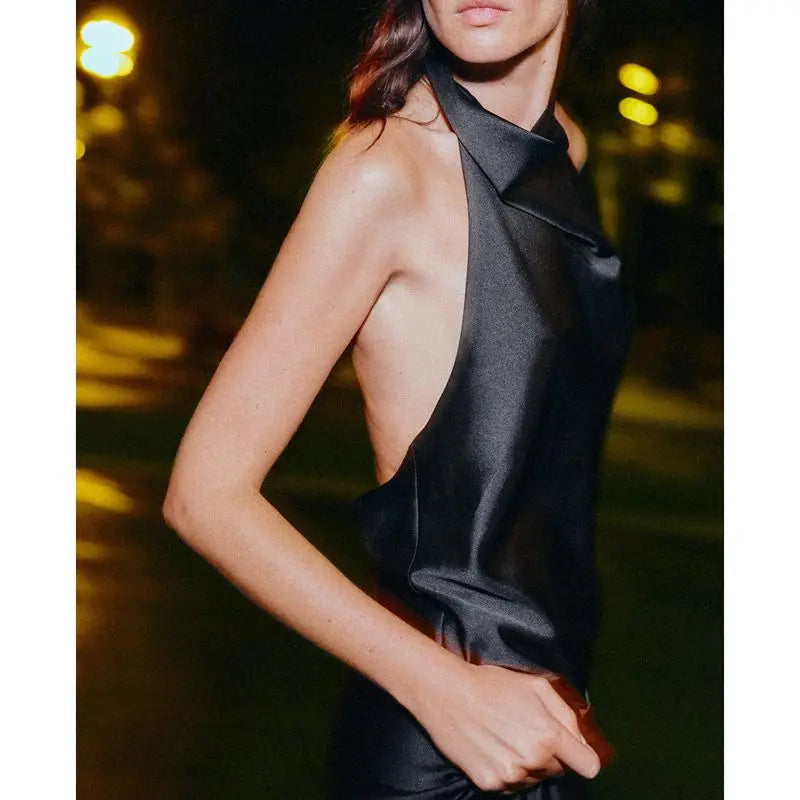 Woman wearing a black sleeveless dress with a blurred background