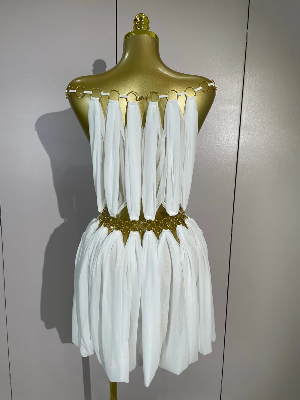 White halter neck mini dress with gold ring details, back view