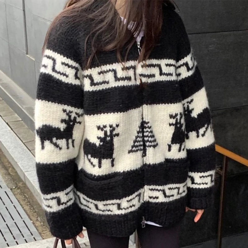 Person wearing a black and white patterned sweater with deer and tree design.