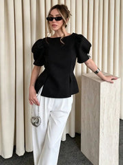 Black puff sleeve peplum blouse with boat neckline and bow detail on sleeve.