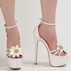 White high-heeled shoes with floral decorations on a light background