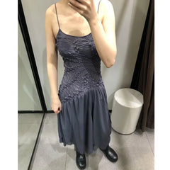 Model wearing a ruched bodice asymmetrical hem spaghetti strap dress