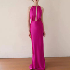 Woman wearing a vibrant pink evening gown against a plain background