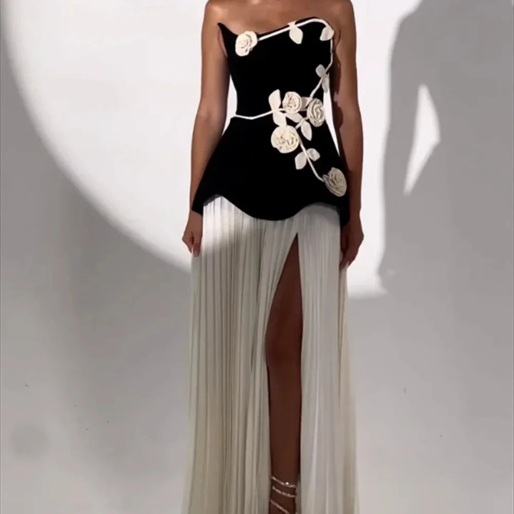 Woman wearing a black dress with white floral designs on a white background