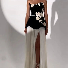 Woman wearing a black dress with white floral designs on a white background