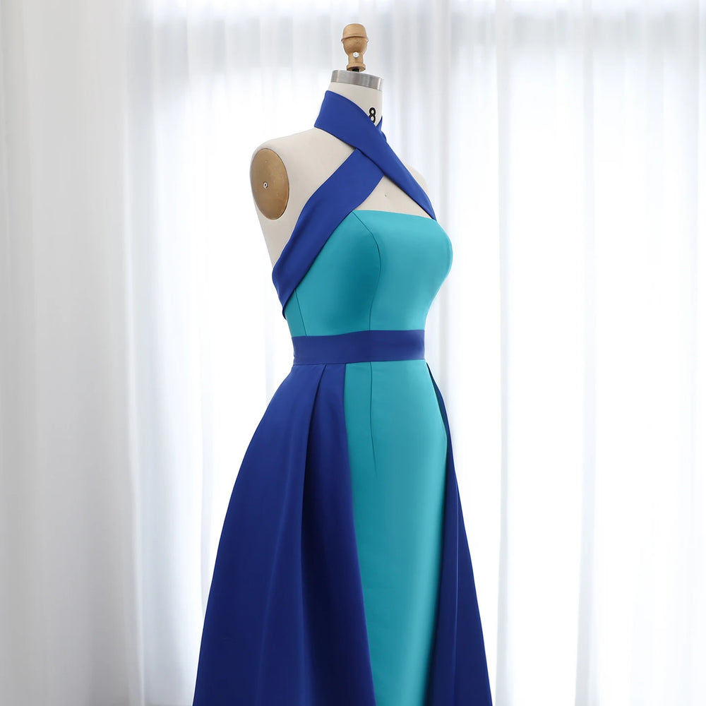 Blue and green dress on a mannequin against a white curtain background