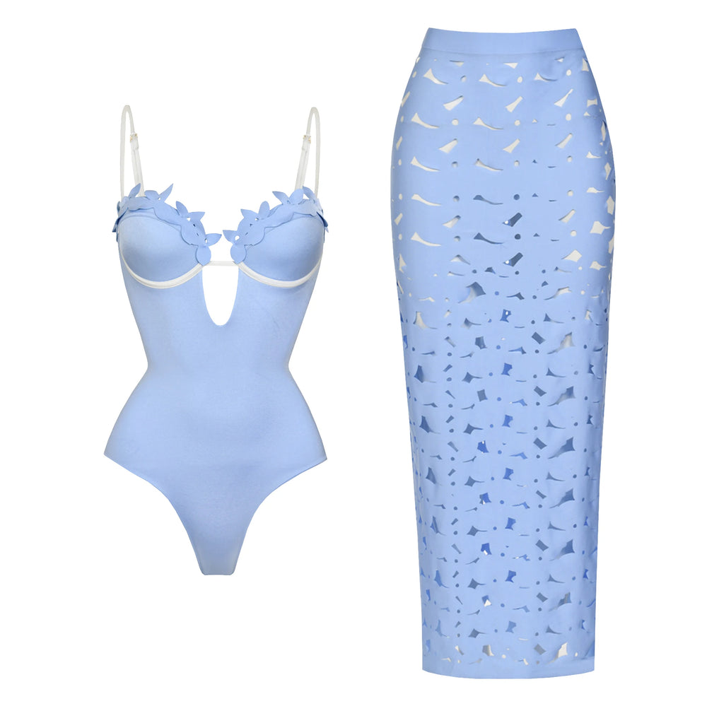 Light blue one-piece swimsuit with floral appliqué neckline and contrast trim, paired with a matching laser-cut maxi skirt.