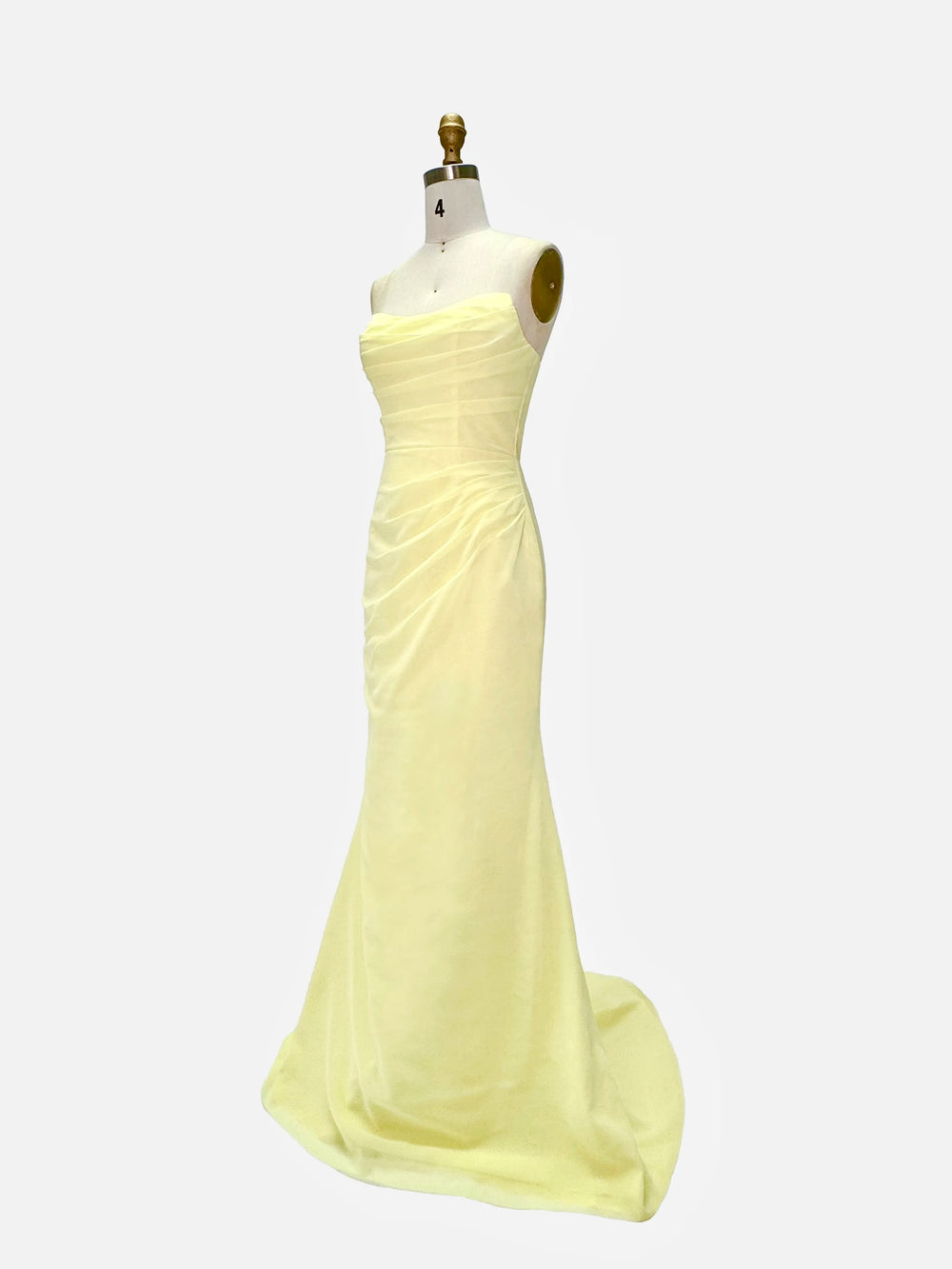 Yellow evening gown on a mannequin against a white background
