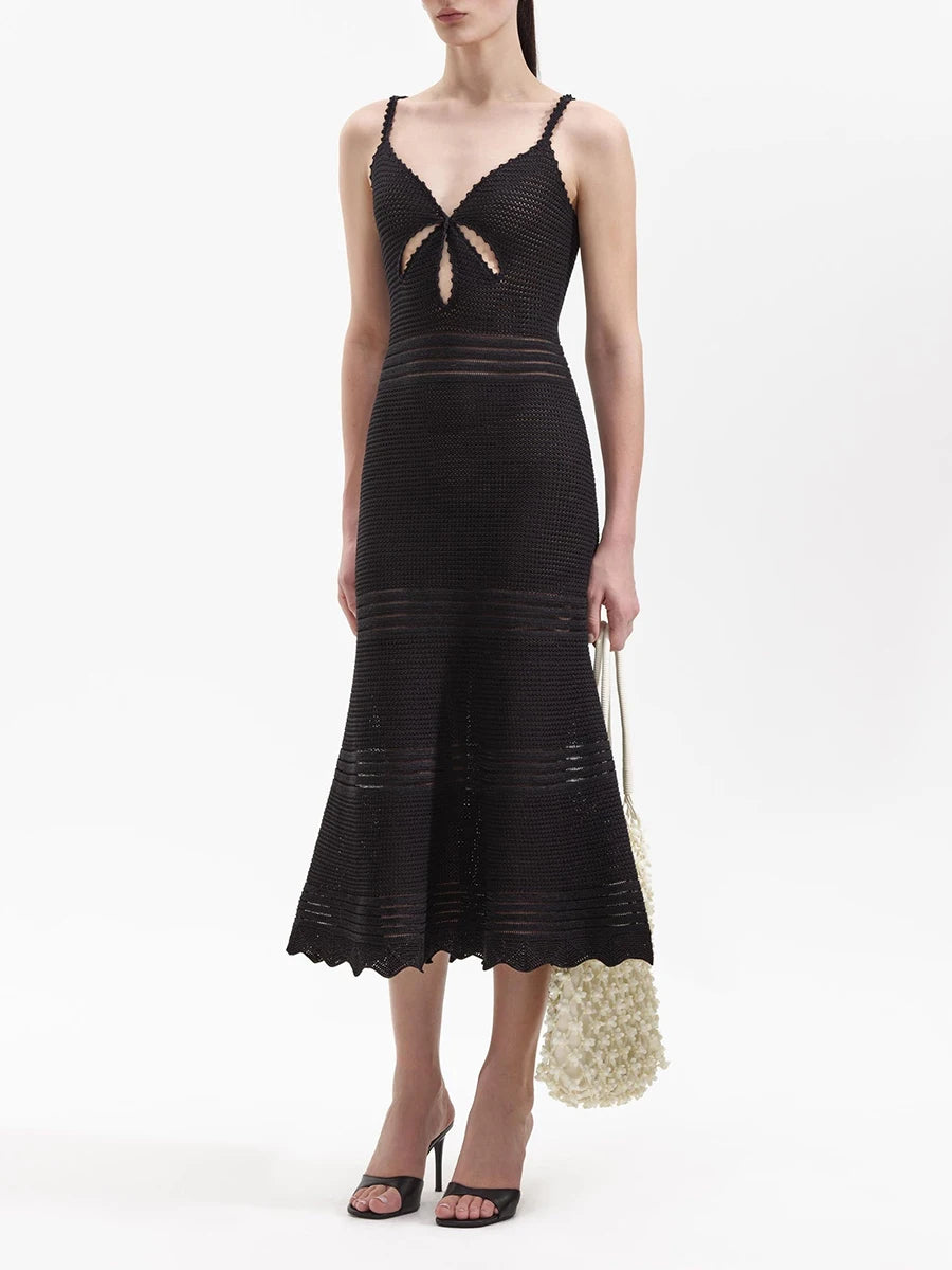 Black knit midi dress with a V-neck cutout and fishtail hem, shown with a handbag
