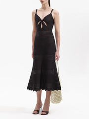 Black knit midi dress with a V-neck cutout and fishtail hem, shown with a handbag