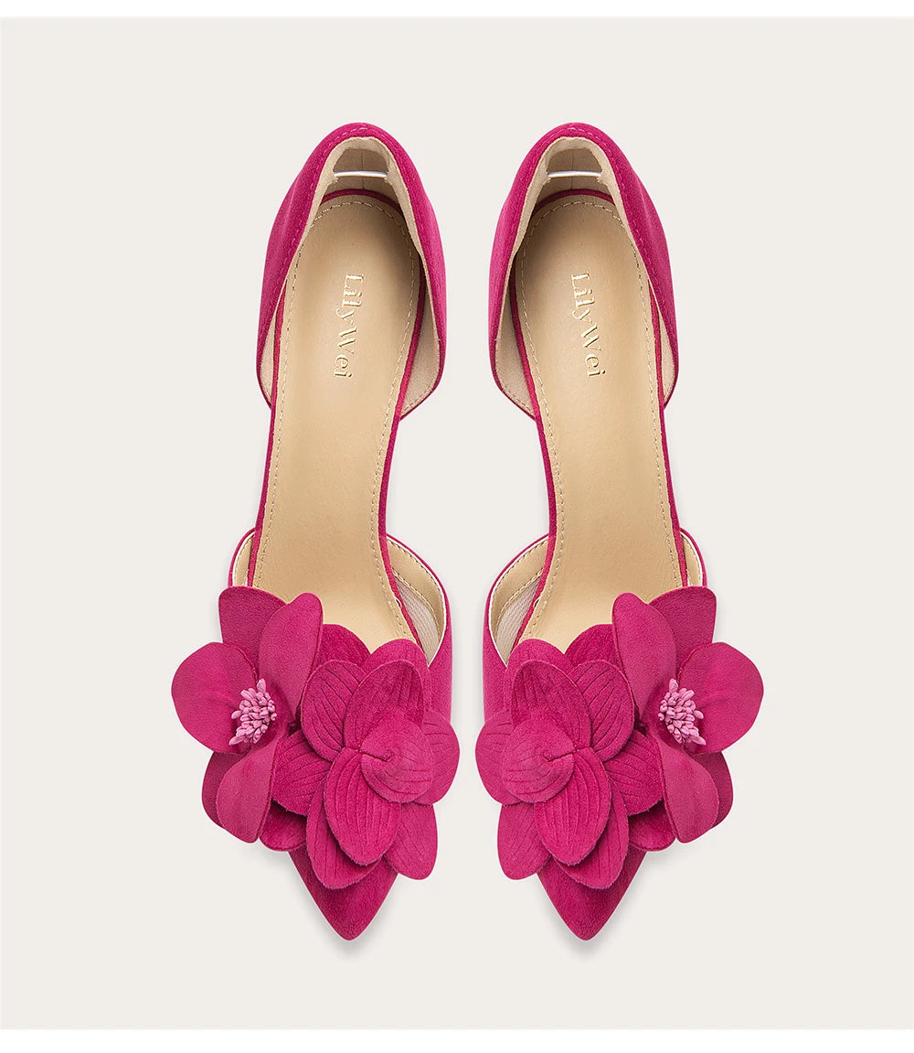 Pair of pink high heels with floral designs on a light background