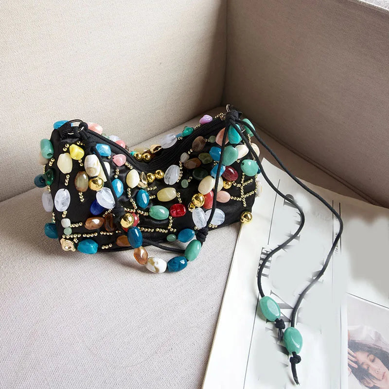 Black shoulder bag decorated with a mosaic of colorful stones and gold beads.