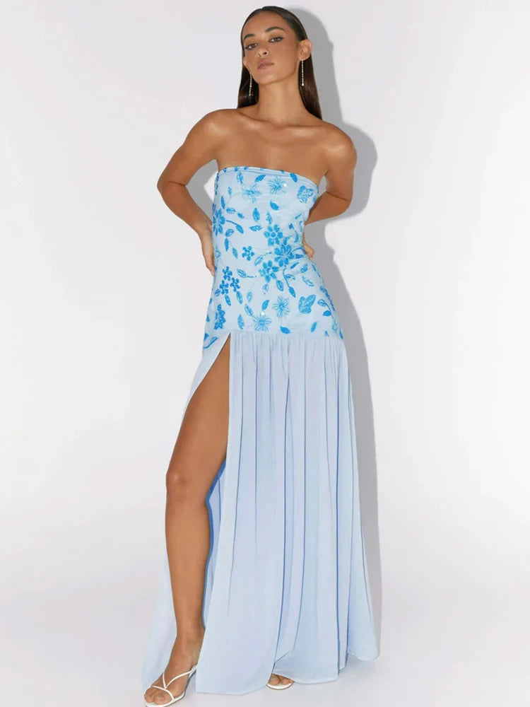 Woman wearing a light blue strapless dress with floral patterns on a white background