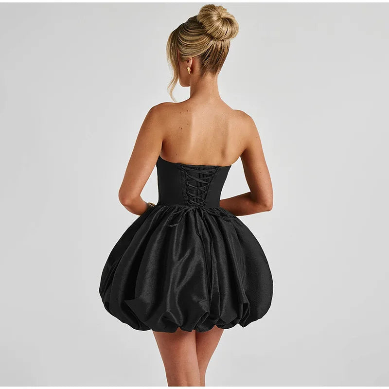 Black strapless dress with a full skirt on a plain background