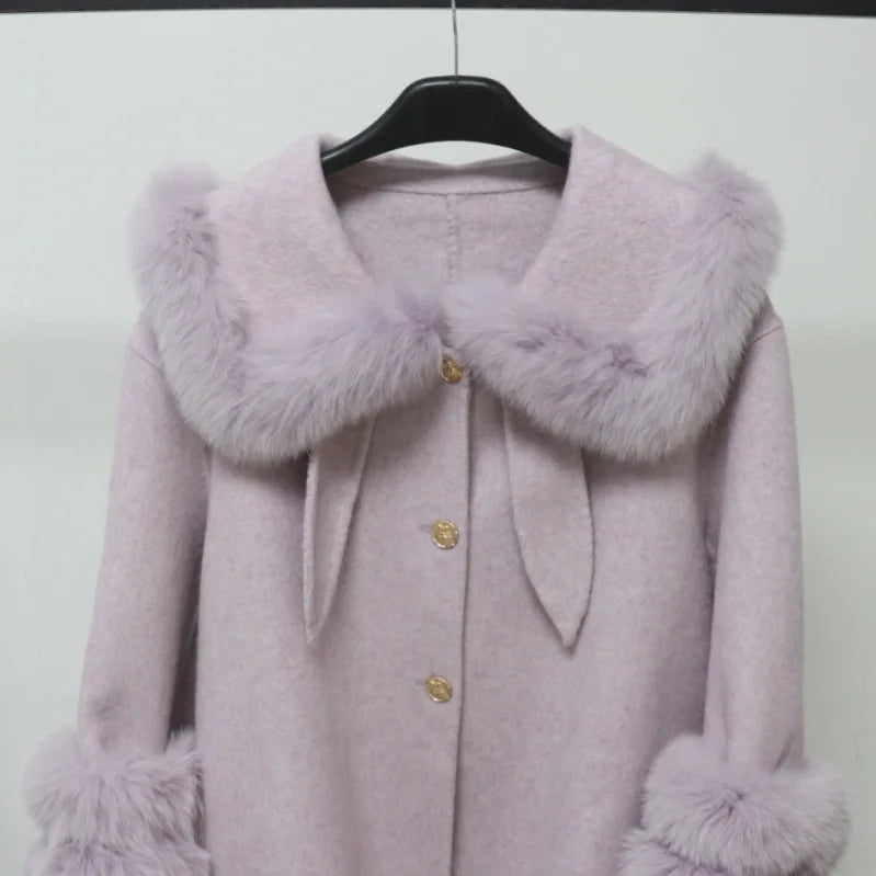 Purple coat with fur collar and cuffs on a hanger against a white background
