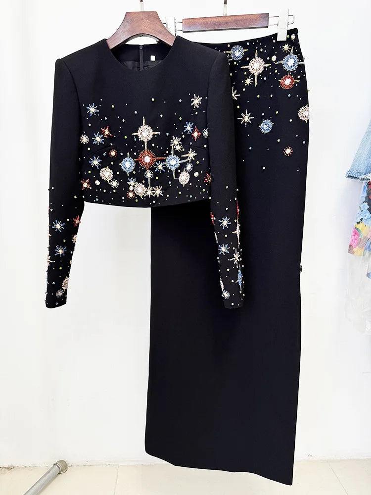 Black embellished cropped top and maxi skirt hanging on a rack