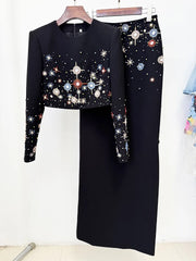 Black embellished cropped top and maxi skirt hanging on a rack