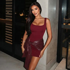 Woman wearing a burgundy dress with leather accents in an indoor setting