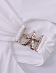 Star-shaped belt buckle on a white fabric background