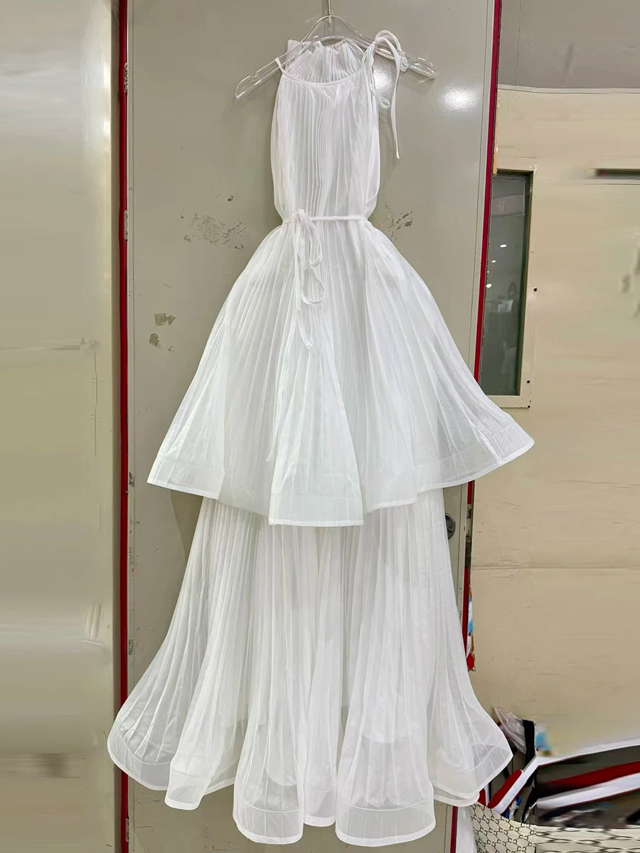 White dress hanging on a rack against a neutral background