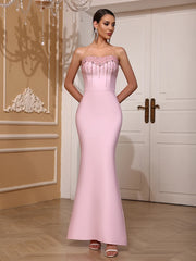 Woman wearing a pink strapless gown in an elegant room.