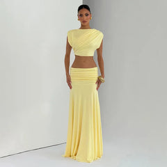 Woman wearing a yellow two-piece outfit against a plain background