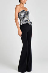 Woman wearing a black and white checkered top and black pants on a white background