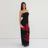 Woman wearing a black strapless dress with red floral patterns
