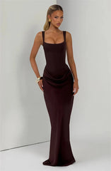 Woman wearing a dark brown evening gown against a plain background