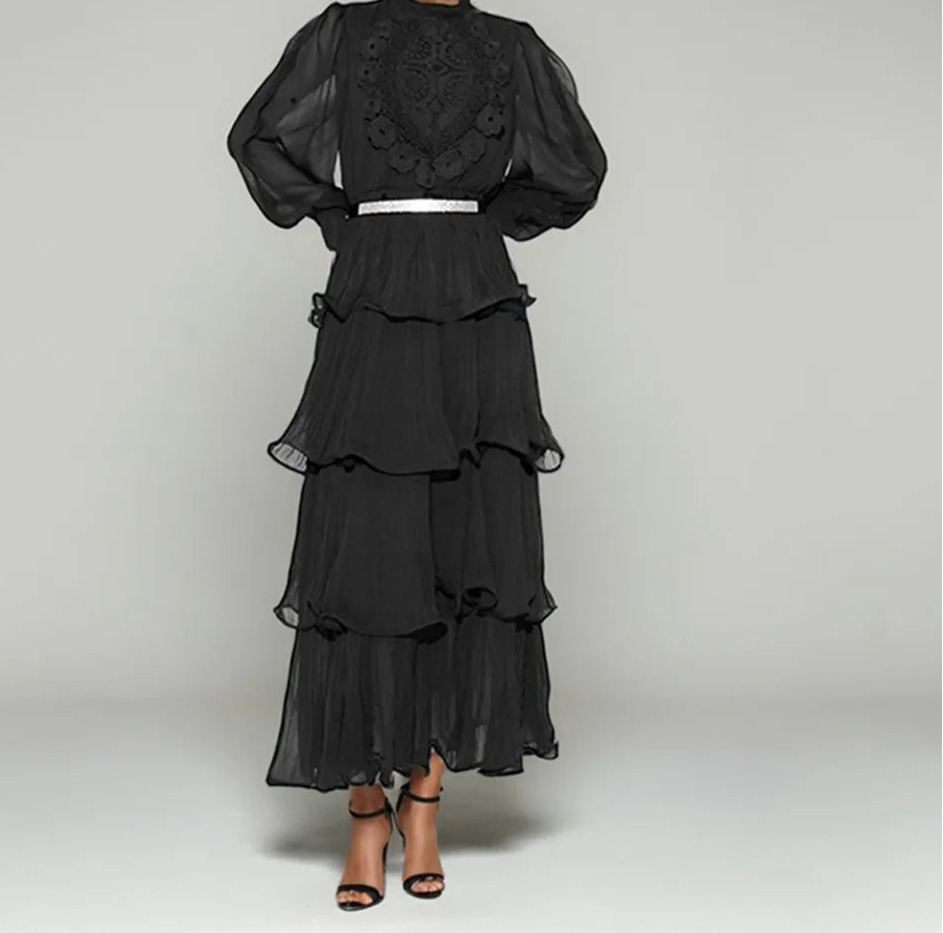 Black lace dress with sheer sleeves on a gray background