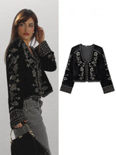 Cropped velvet jacket with intricate silver embroidery, worn by a model.