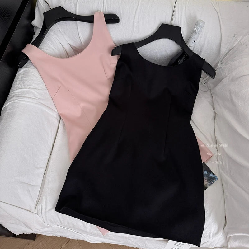 Pink and black sleeveless mini dresses on hangers