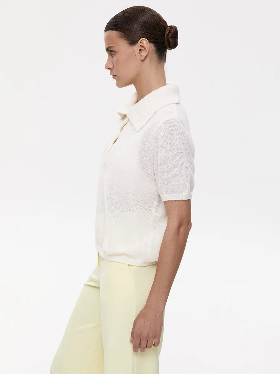Woman wearing a white shirt and light yellow pants on a white background