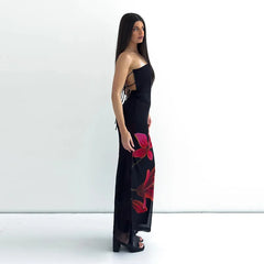 Woman wearing a black dress with red floral patterns