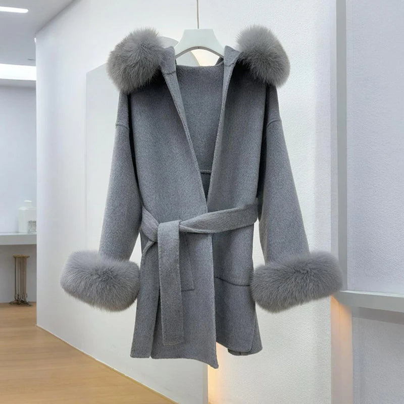 Gray coat with fur trim on a hanger against a white background
