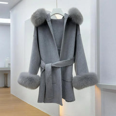 Gray coat with fur trim on a hanger against a white background