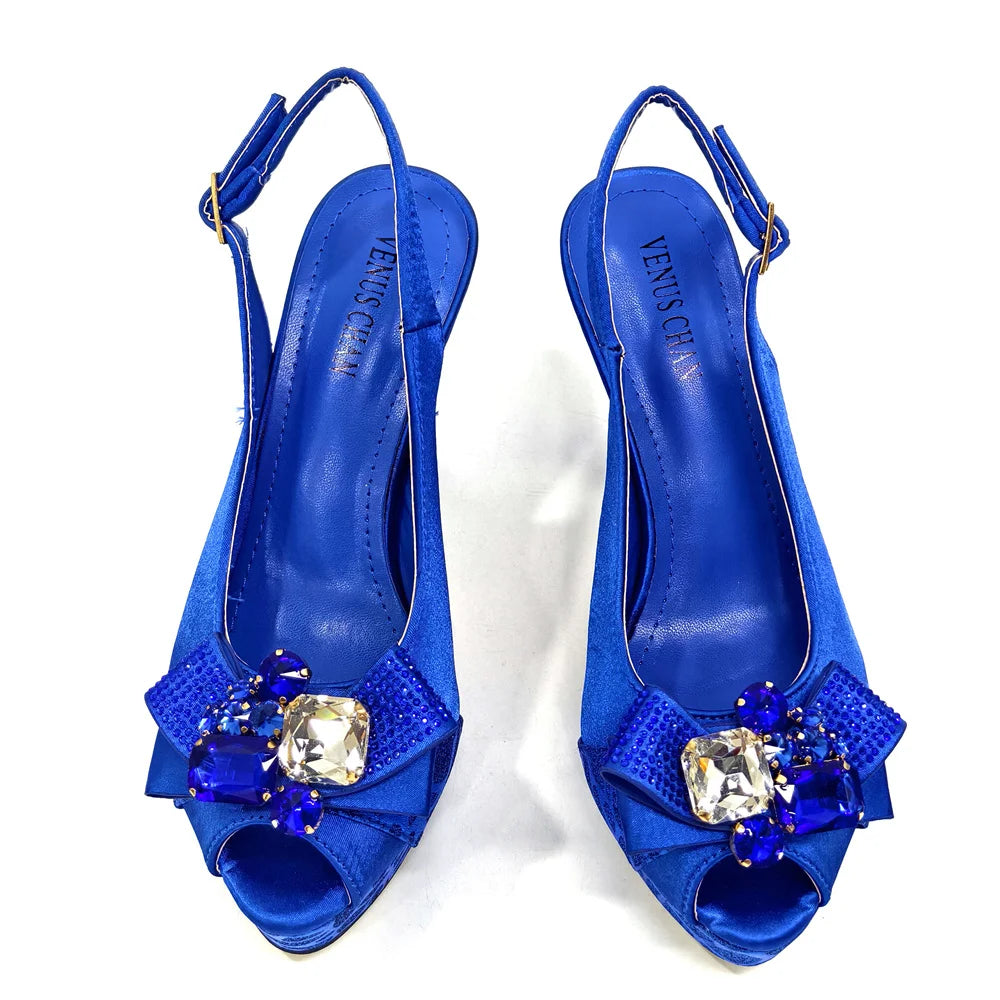 Pair of blue high-heeled shoes with decorative elements on a white background