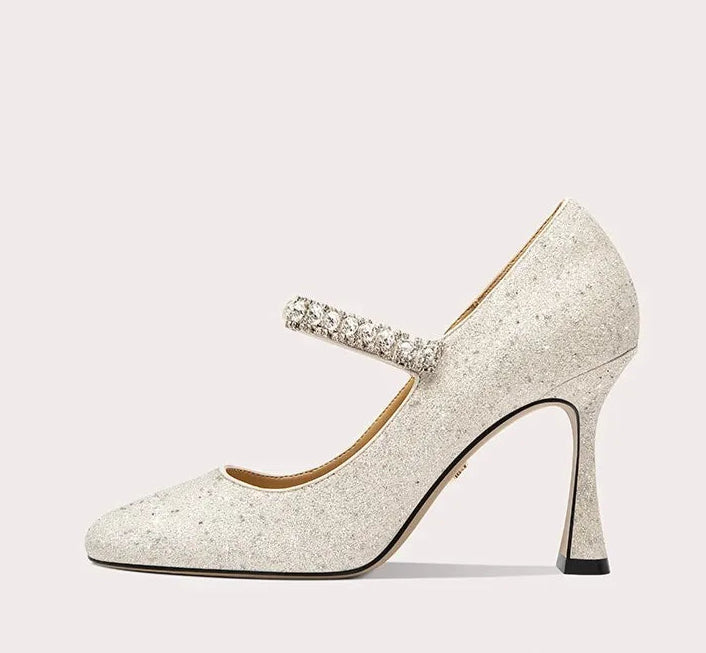 Sparkly high-heeled shoe with a decorative strap on a white background