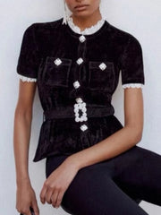 Black velvet top with white lace details worn by a model against a white background