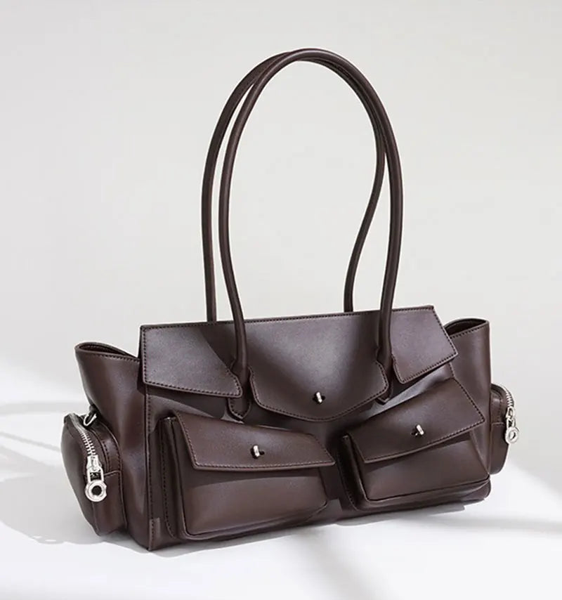 Brown handbag with multiple pockets and zippers on a white background
