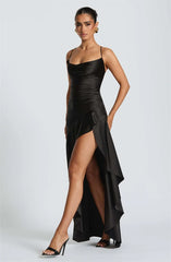 Woman wearing a black dress with a high slit on a white background