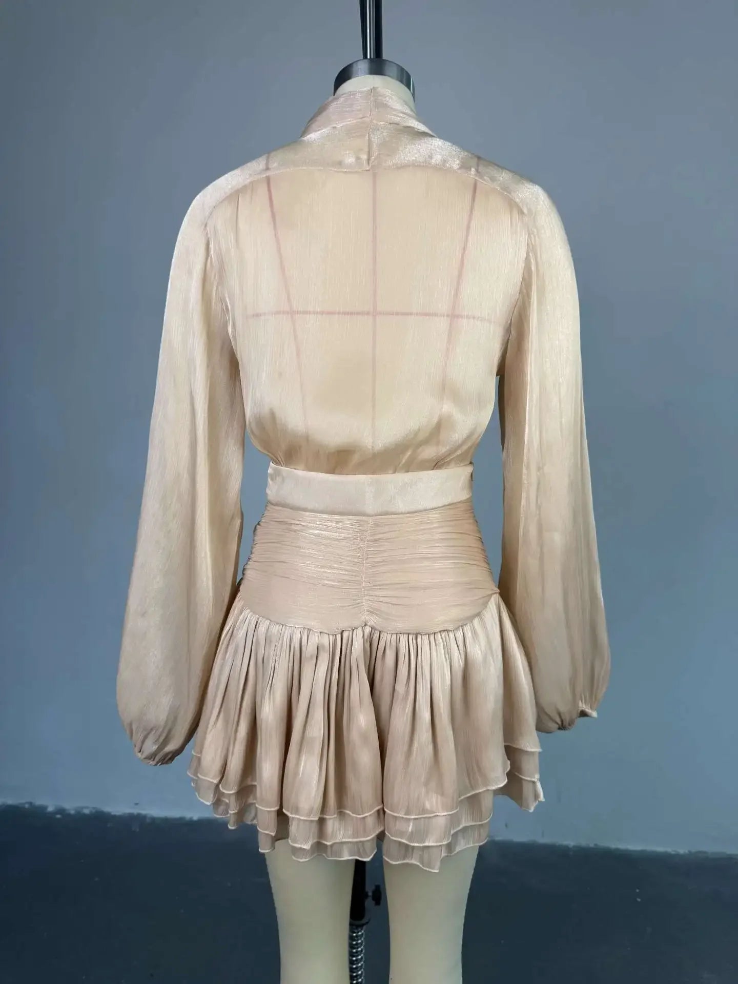 Beige dress on a mannequin against a gray background