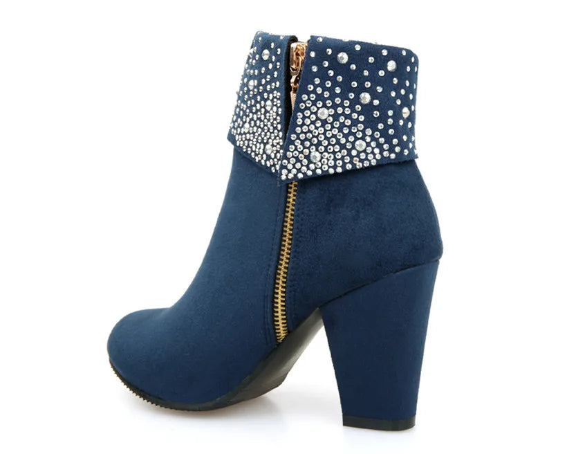 Blue ankle boot with studded detailing on a white background