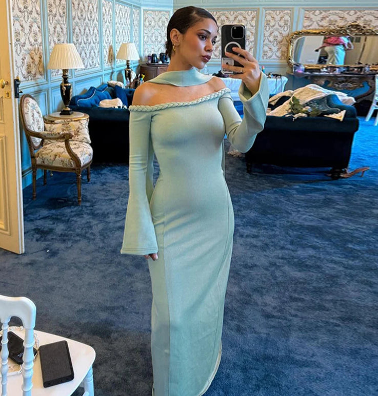 Woman in a light green off-shoulder dress taking a mirror selfie in an ornate room.