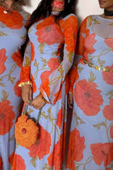 Two women wearing floral dresses with orange and blue colors.