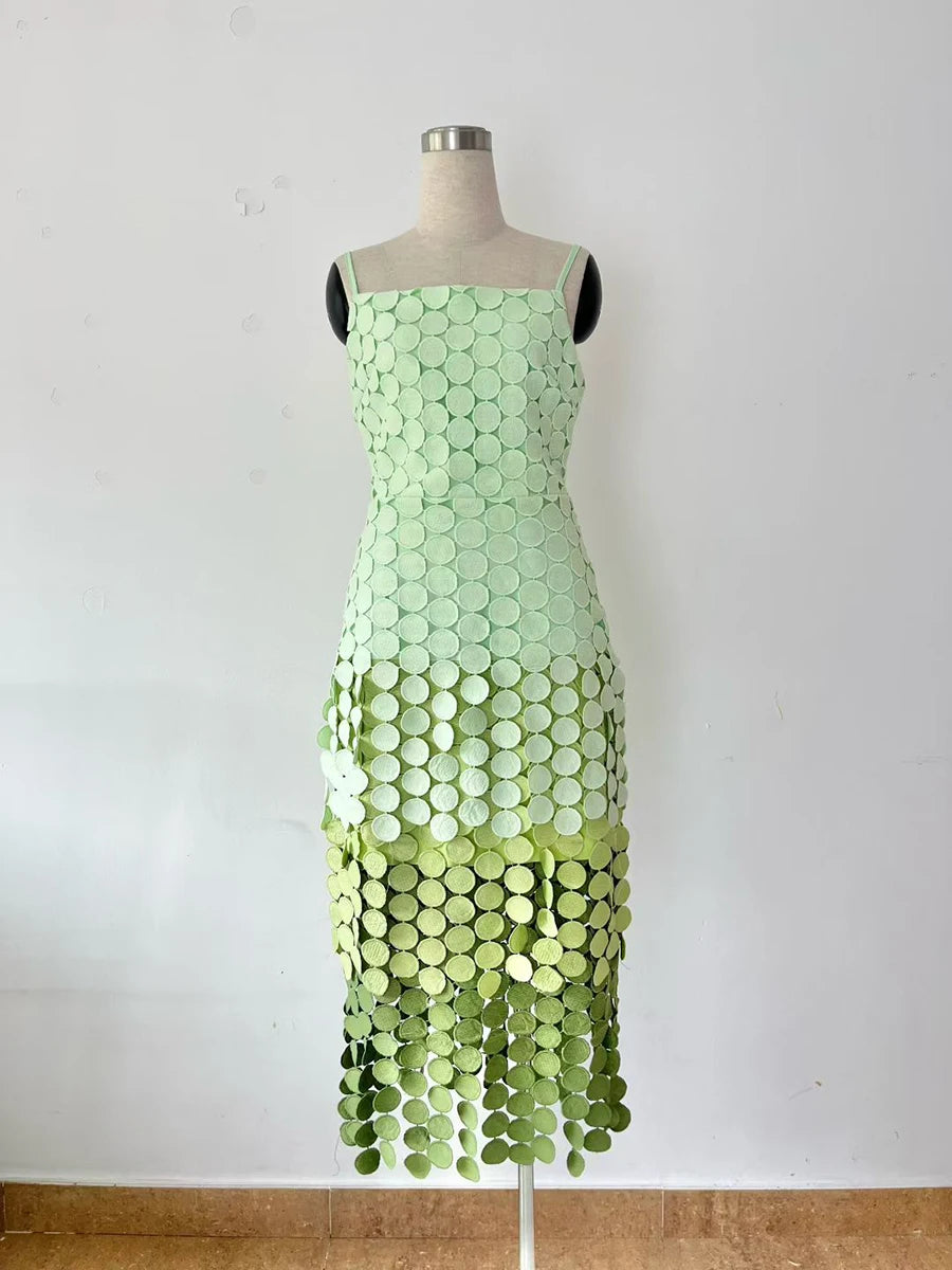 Green dress with circular pattern on a mannequin against a white background