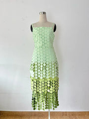 Green dress with circular pattern on a mannequin against a white background