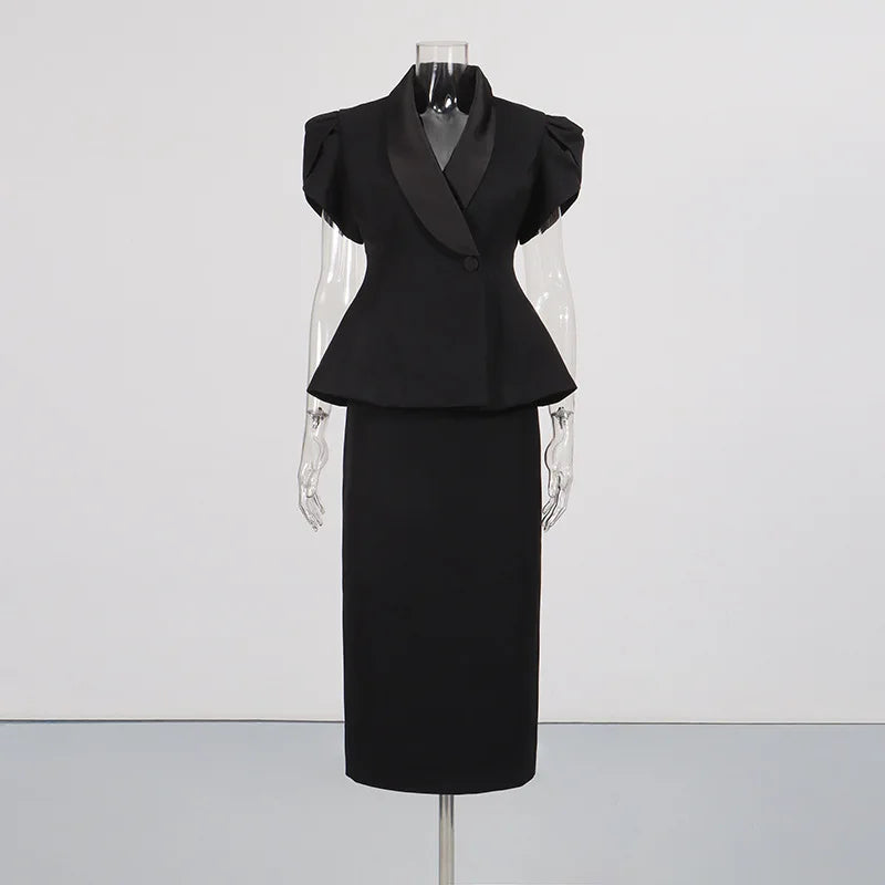 Black peplum blazer with satin lapels and a black midi skirt displayed on a mannequin.