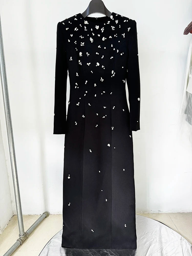 Black long sleeve maxi dress with all-over rhinestone embellishments displayed on a hanger