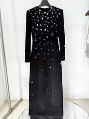 Black long sleeve maxi dress with all-over rhinestone embellishments displayed on a hanger
